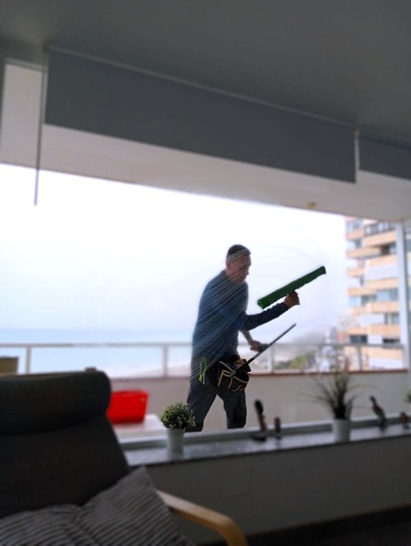 Técnico limpiando escaparate comercial en Málaga